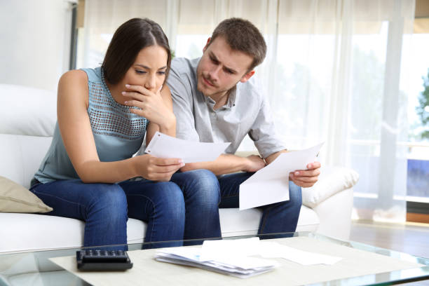 Couple reviewing bills at their kitchen table